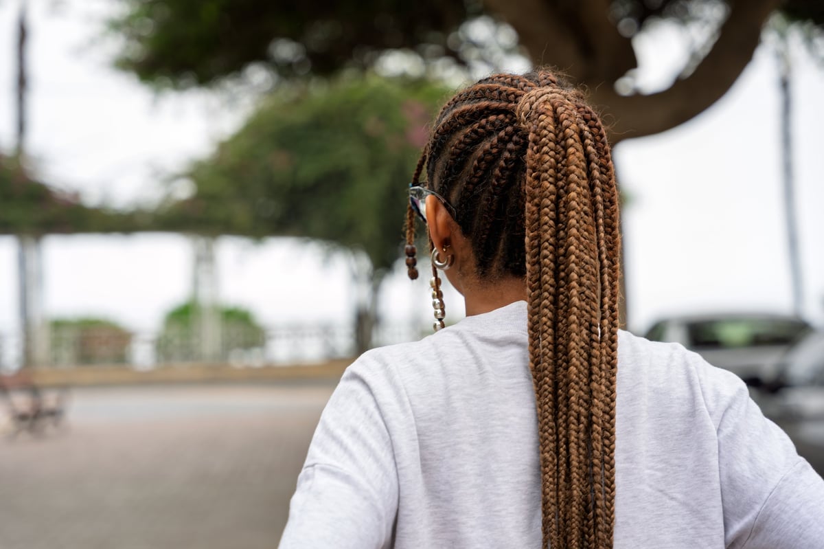 Woman with long box braids in a high ponytail